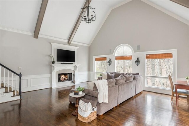 living area featuring a decorative wall, wood finished floors, crown molding, and plenty of natural light