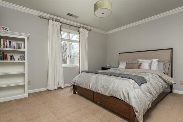carpeted bedroom featuring baseboards, ensuite bath, ornamental molding, and visible vents