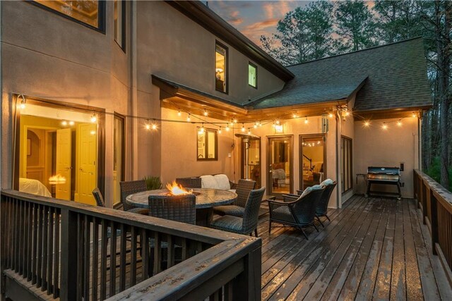 back of property with a deck, stucco siding, stairs, and a chimney