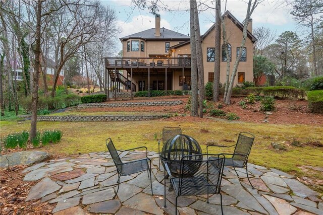 view of patio / terrace with a wooded view and a fire pit