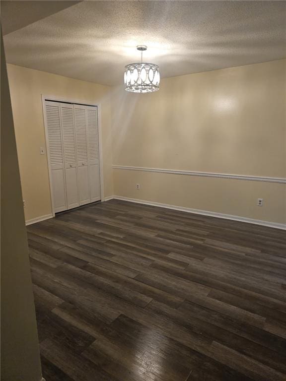 6851 Roswell Rd Unit 15, Atlanta, GA 30328 - unfurnished dining area with dark wood-style flooring, a chandelier, and a textured ceiling