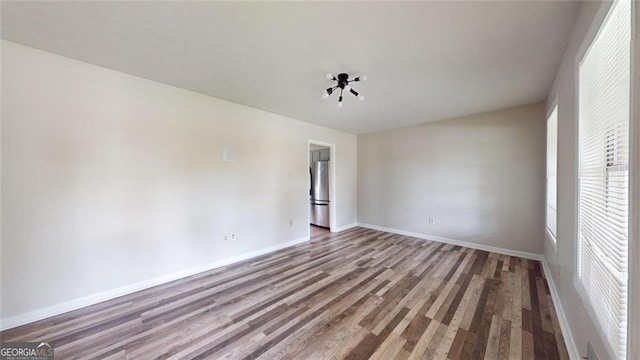 empty room with wood finished floors and baseboards