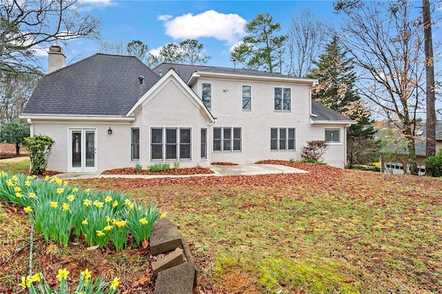 back of property featuring stucco siding, a chimney, and a patio area