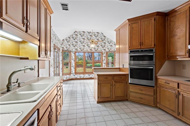 kitchen with double oven, vaulted ceiling, light countertops, and a sink