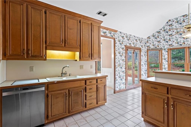 kitchen with brown cabinetry, wallpapered walls, a sink, light countertops, and stainless steel dishwasher