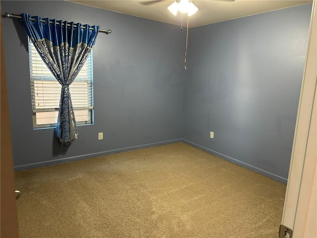 carpeted spare room featuring ceiling fan