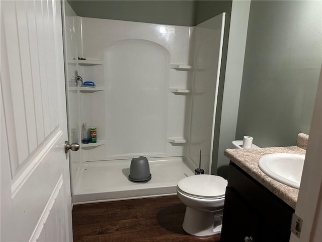 bathroom featuring vanity, toilet, a shower, and hardwood / wood-style floors