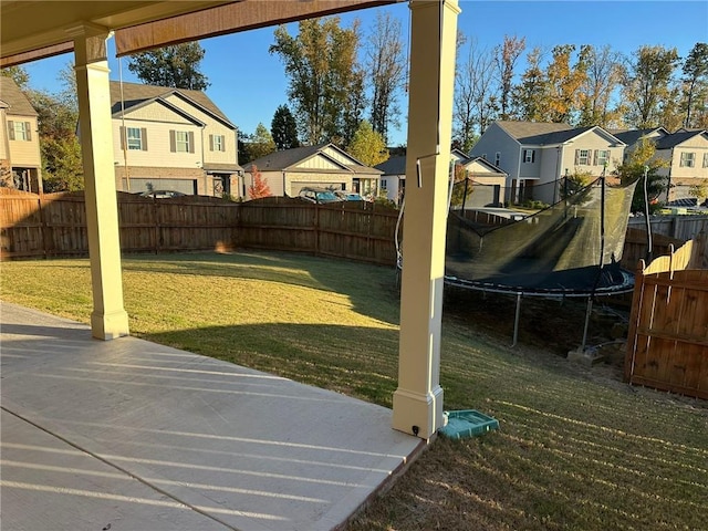 view of yard featuring a trampoline and a patio