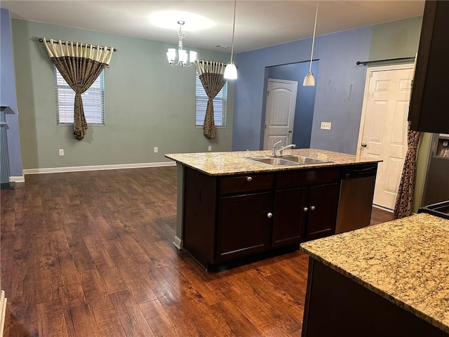 kitchen with dark wood-type flooring, an island with sink, sink, pendant lighting, and stainless steel dishwasher