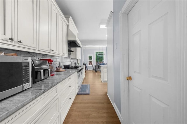 9035 Walnut Cove Ct, Gainesville, GA 30506 - kitchen with appliances with stainless steel finishes, light wood finished floors, white cabinetry, decorative backsplash, and light stone countertops