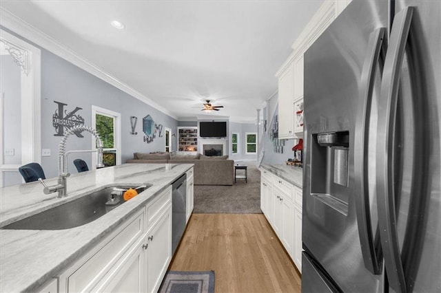 9035 Walnut Cove Ct, Gainesville, GA 30506 - kitchen with appliances with stainless steel finishes, a sink, ceiling fan, a fireplace, and white cabinetry