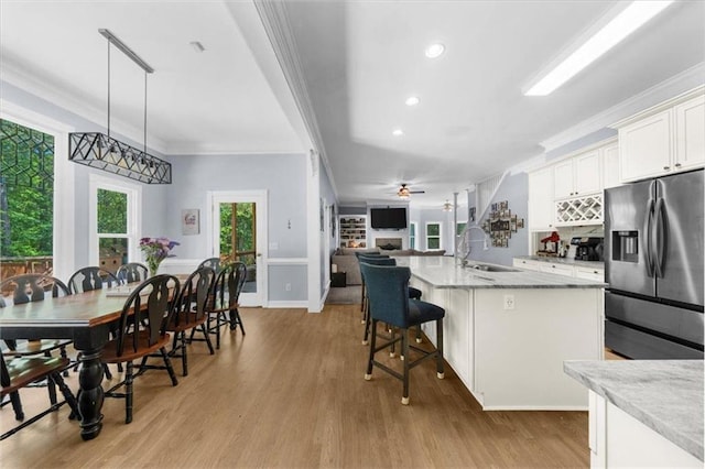 9035 Walnut Cove Ct, Gainesville, GA 30506 - kitchen featuring stainless steel fridge, a sink, crown molding, light wood-style flooring, and white cabinetry