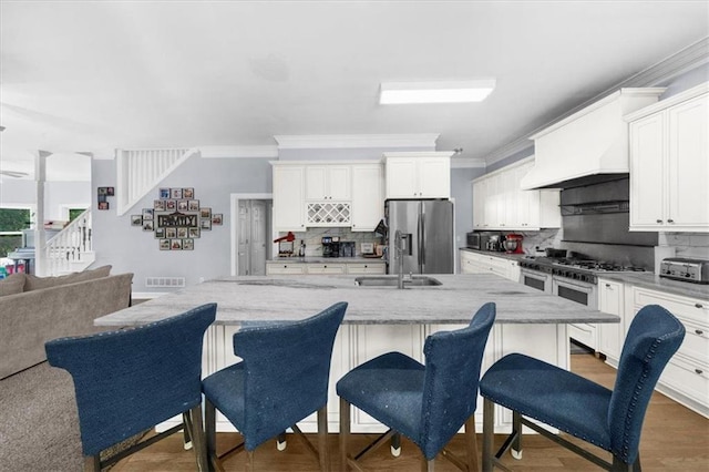 9035 Walnut Cove Ct, Gainesville, GA 30506 - kitchen featuring appliances with stainless steel finishes, a sink, open floor plan, backsplash, and ornamental molding