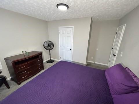 carpeted bedroom with baseboards and a textured ceiling