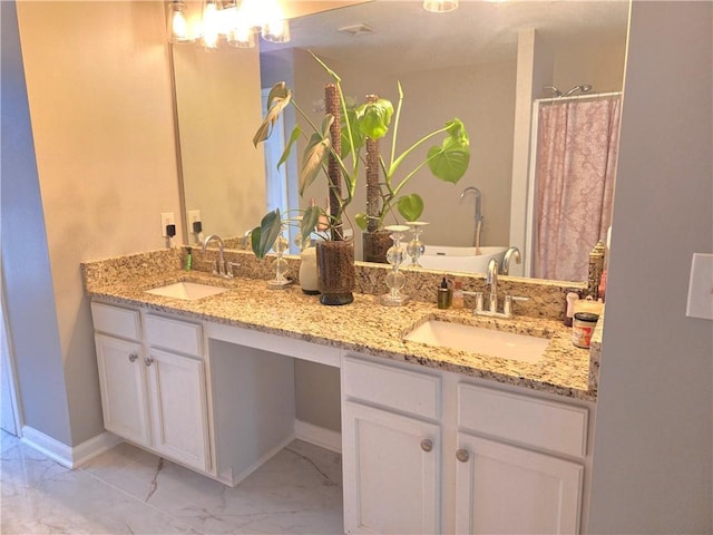 full bath with double vanity, marble finish floor, a sink, and a soaking tub