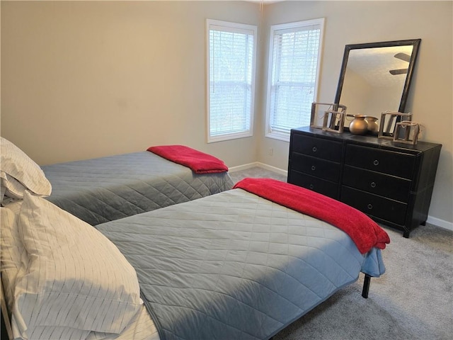 bedroom with baseboards and light colored carpet