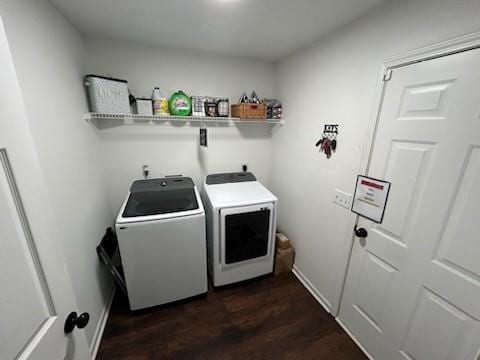 washroom with dark wood-style flooring, laundry area, baseboards, and washing machine and clothes dryer