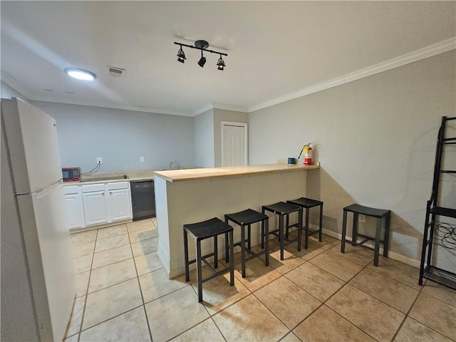 kitchen with a peninsula, white cabinetry, light countertops, and freestanding refrigerator