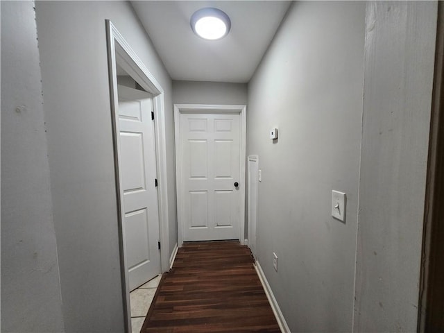 hallway with baseboards and dark wood finished floors