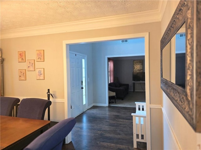 entryway featuring ornamental molding, visible vents, a textured ceiling, and dark wood-style floors