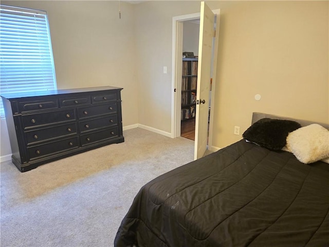 bedroom featuring light colored carpet and baseboards