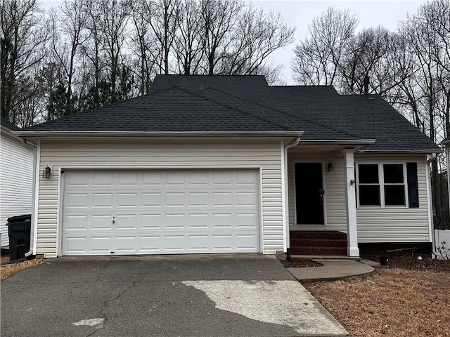 single story home with a garage, driveway, and roof with shingles