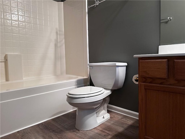 full bath featuring baseboards, toilet, shower / tub combination, wood finished floors, and vanity