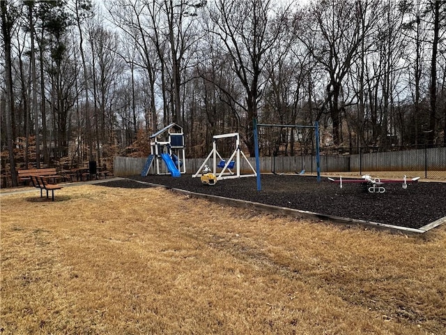 community jungle gym featuring a yard and fence