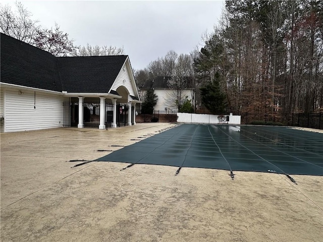 view of swimming pool featuring a patio and fence