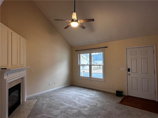 unfurnished living room with light carpet, high vaulted ceiling, a premium fireplace, baseboards, and ceiling fan