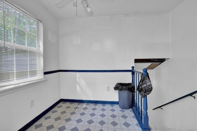staircase featuring baseboards, a ceiling fan, and tile patterned floors