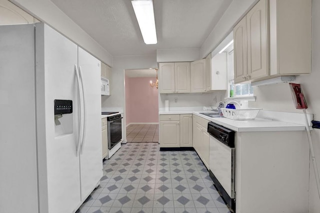 kitchen featuring white appliances, white cabinetry, light floors, and light countertops