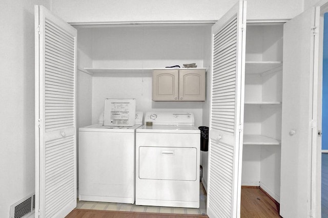 laundry area with visible vents, laundry area, light wood finished floors, and washing machine and dryer