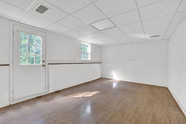 interior space with visible vents, a drop ceiling, and wood finished floors