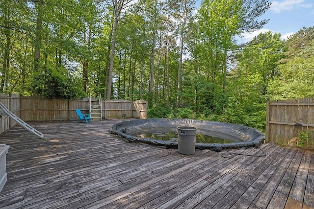 wooden terrace with fence and a fenced in pool