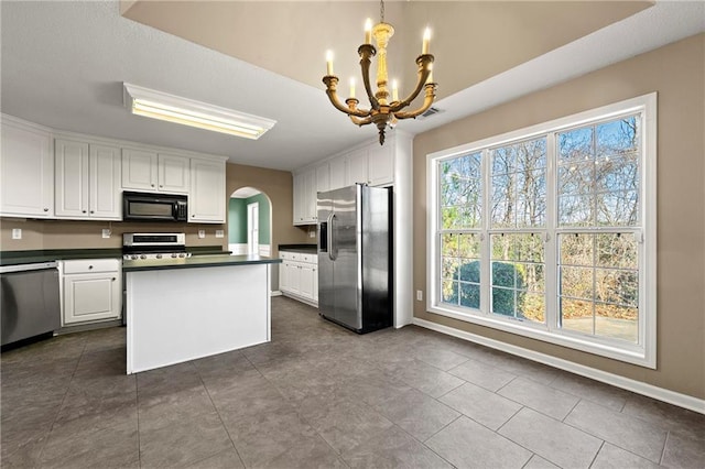 kitchen with white cabinetry, hanging light fixtures, stainless steel appliances, and a notable chandelier