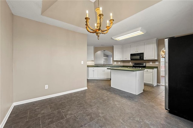 kitchen featuring stainless steel fridge, white cabinets, and an inviting chandelier