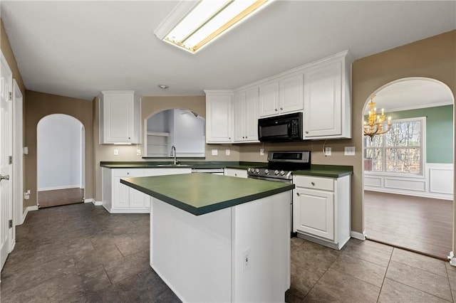 kitchen featuring white cabinets, stainless steel stove, a chandelier, and sink