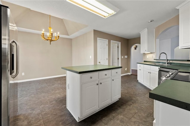 kitchen with a notable chandelier, white cabinetry, sink, and appliances with stainless steel finishes