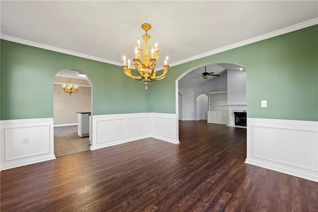 spare room with ceiling fan with notable chandelier, dark hardwood / wood-style floors, lofted ceiling, and crown molding