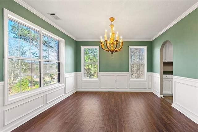 unfurnished dining area with crown molding, dark hardwood / wood-style flooring, and a notable chandelier