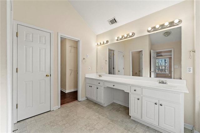 bathroom featuring vanity and lofted ceiling