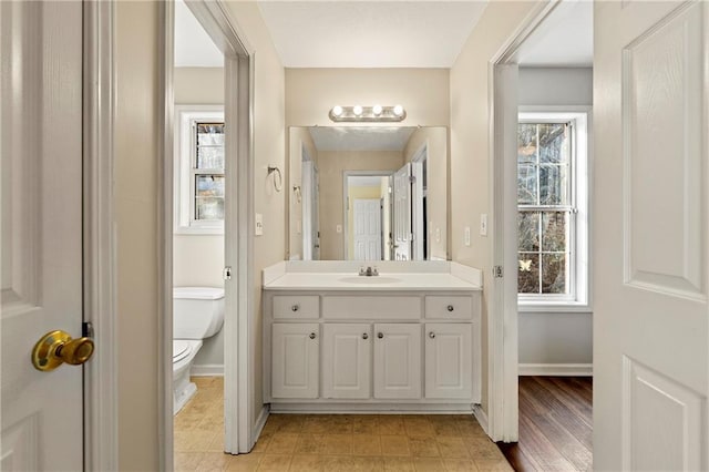 bathroom with a wealth of natural light, vanity, and toilet