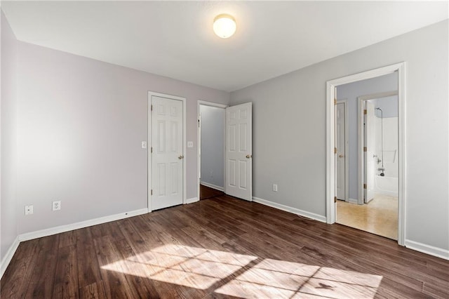 unfurnished bedroom with dark hardwood / wood-style floors and a closet