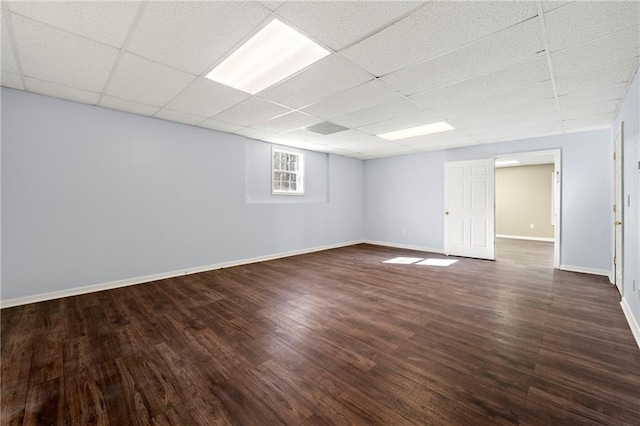 basement featuring a drop ceiling and dark wood-type flooring