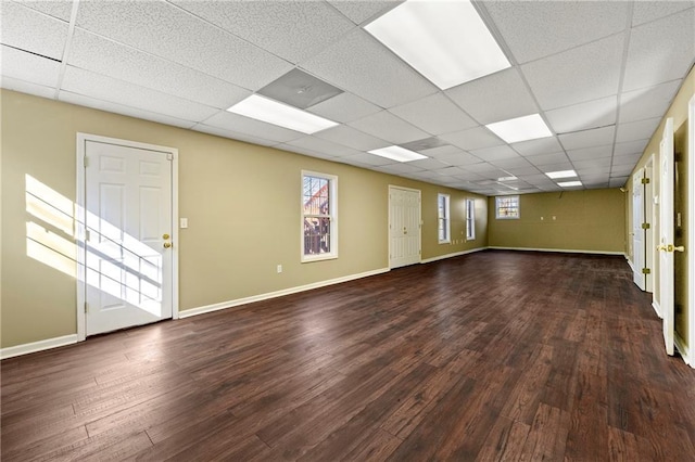 unfurnished room featuring a paneled ceiling, plenty of natural light, and hardwood / wood-style flooring