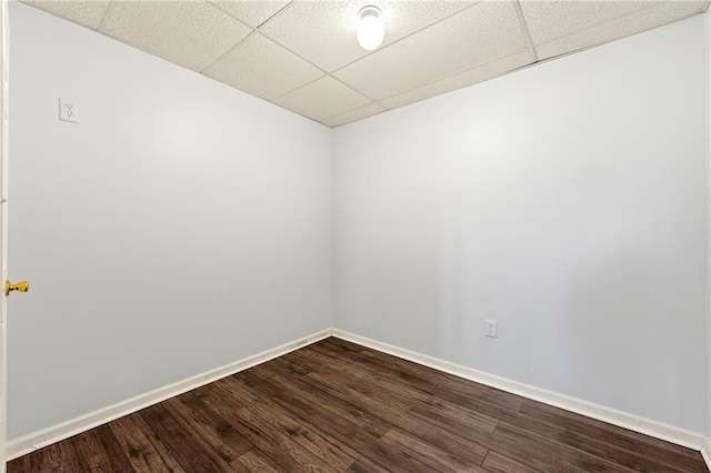 spare room featuring wood-type flooring and a paneled ceiling