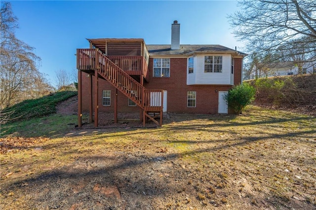 rear view of property featuring a lawn and a wooden deck