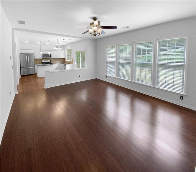 unfurnished living room with ceiling fan and dark hardwood / wood-style flooring