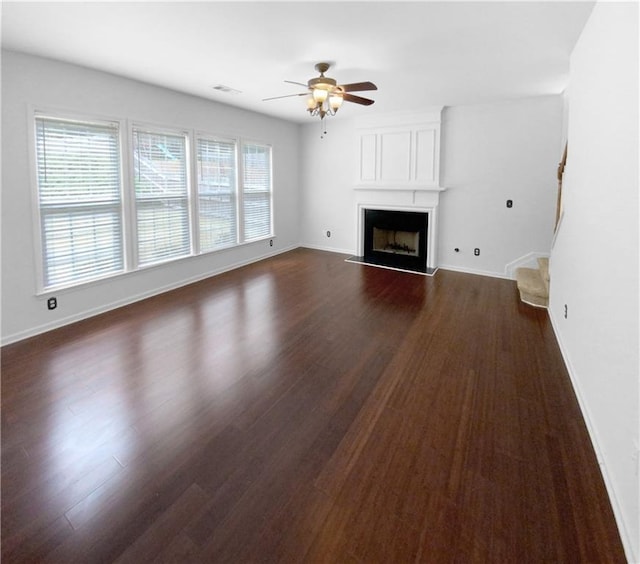 unfurnished living room with dark wood-type flooring and ceiling fan